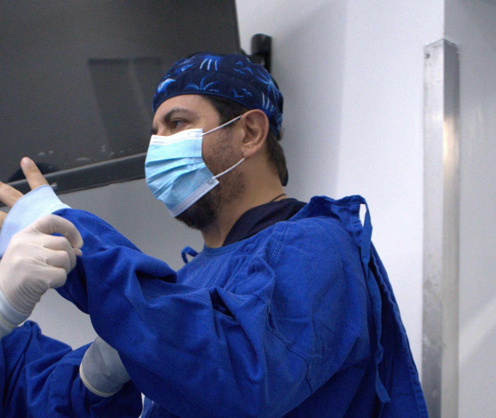 El Dr. Saad Barhoum poniéndose los guantes quirúrgicos antes de operar.